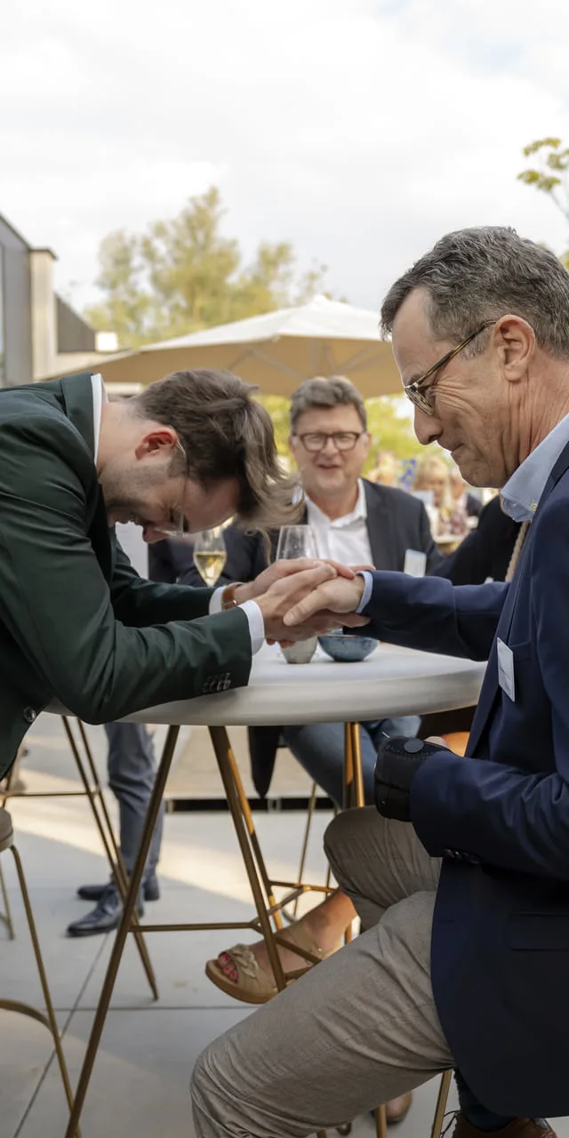 Gasten volgen een close-up experiment aan een statafel